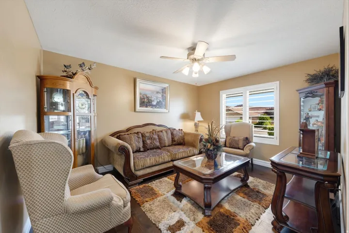 Living area with wood-finish flooring and a ceiling fan