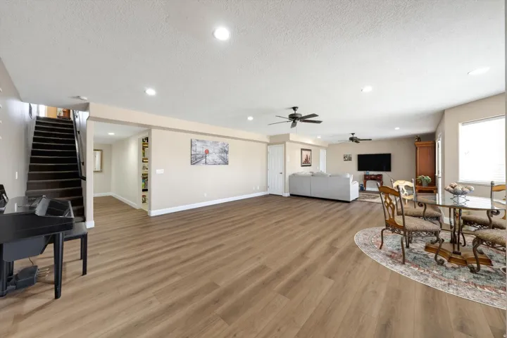 Expansive room featuring wood-finish flooring, recessed lighting, and a ceiling fan