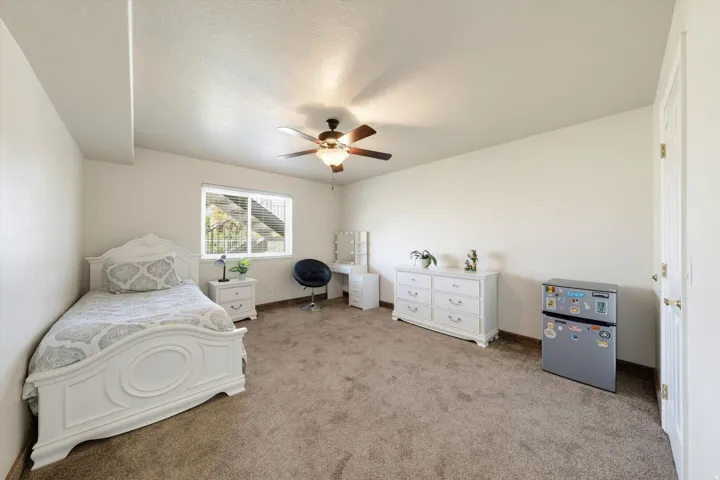 Spacious interior room with neutral-toned carpet flooring and light-colored walls