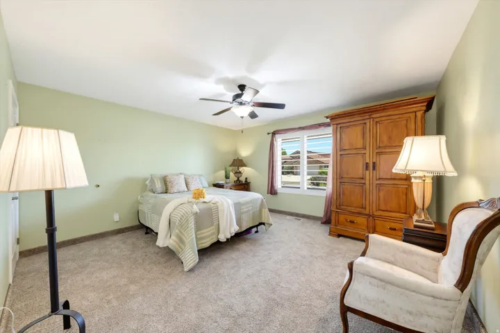 Carpeted room with light green walls and a vaulted ceiling
