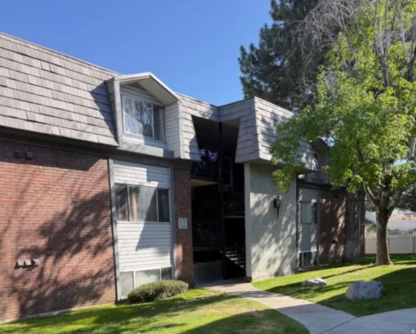 Exterior featuring multi-level architecture, brick and siding finishes, and a distinctive mansard-style shingle roof