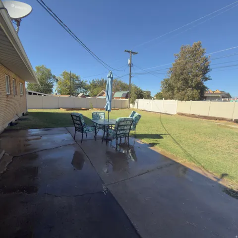 Expansive concrete patio with a surrounding lawn