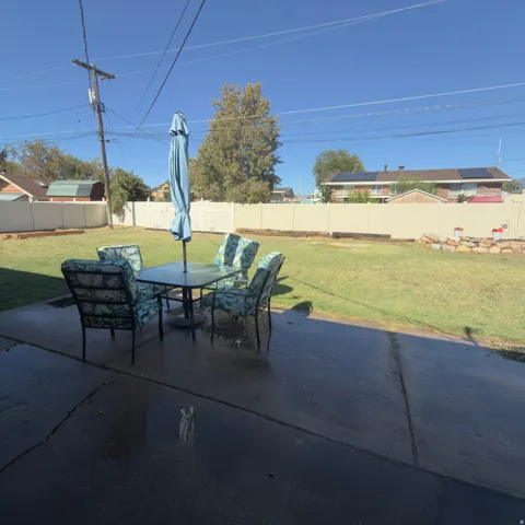 Expansive lawn area with a perimeter privacy fence and a concrete patio