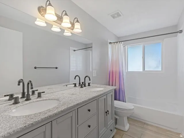 Dual vanity with integrated sinks, speckled countertop, and dark-finish fixtures