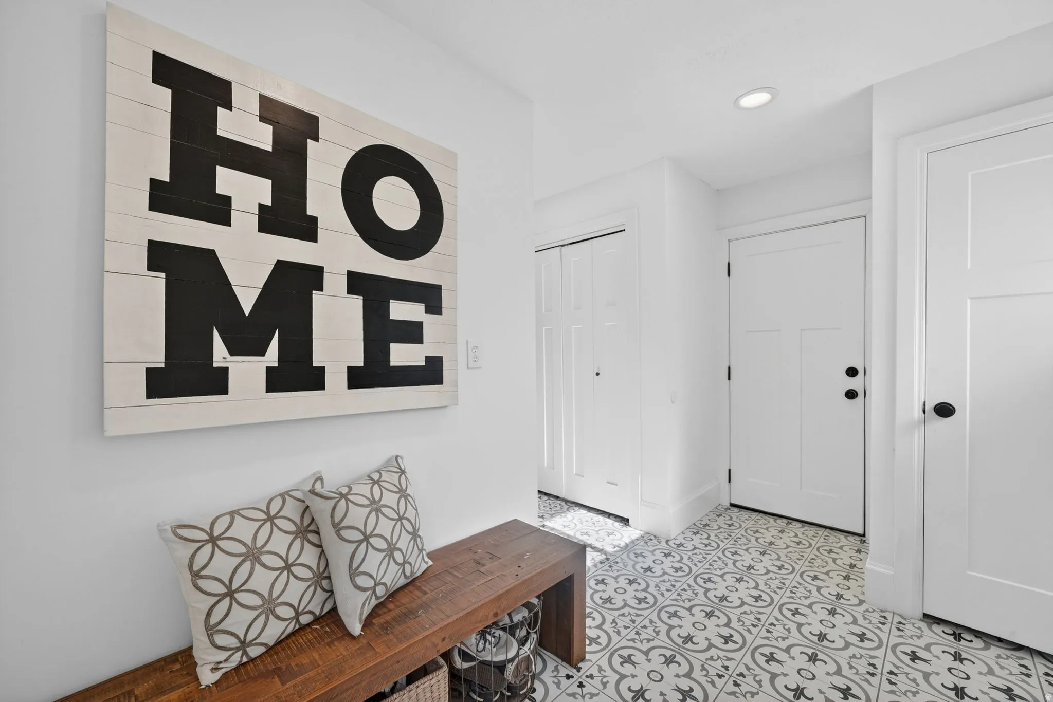 Entryway featuring patterned floor tile, recessed lighting, white walls, and multiple white panel doors