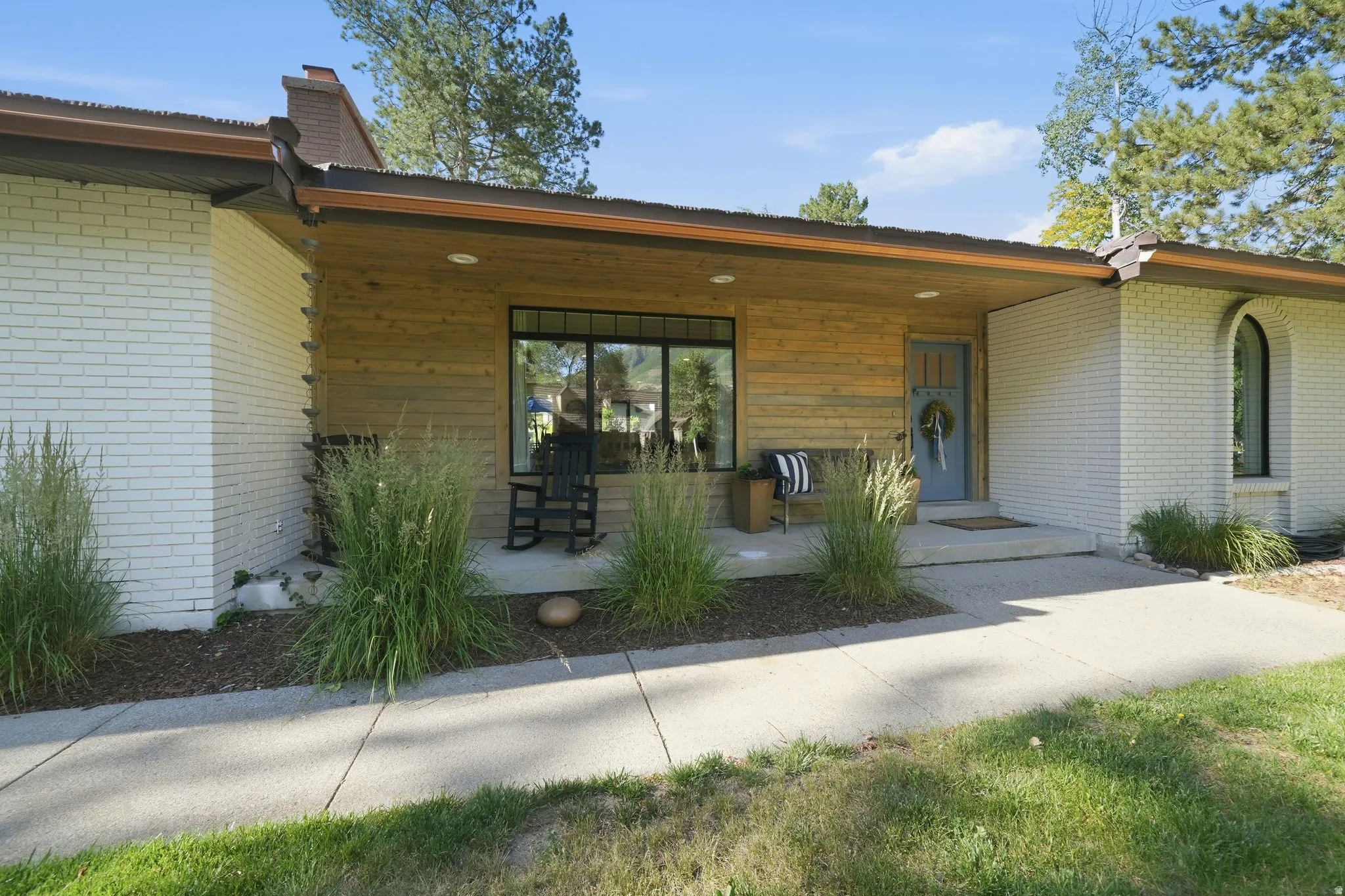 Mid-century modern exterior featuring white painted brick and horizontal wood paneling