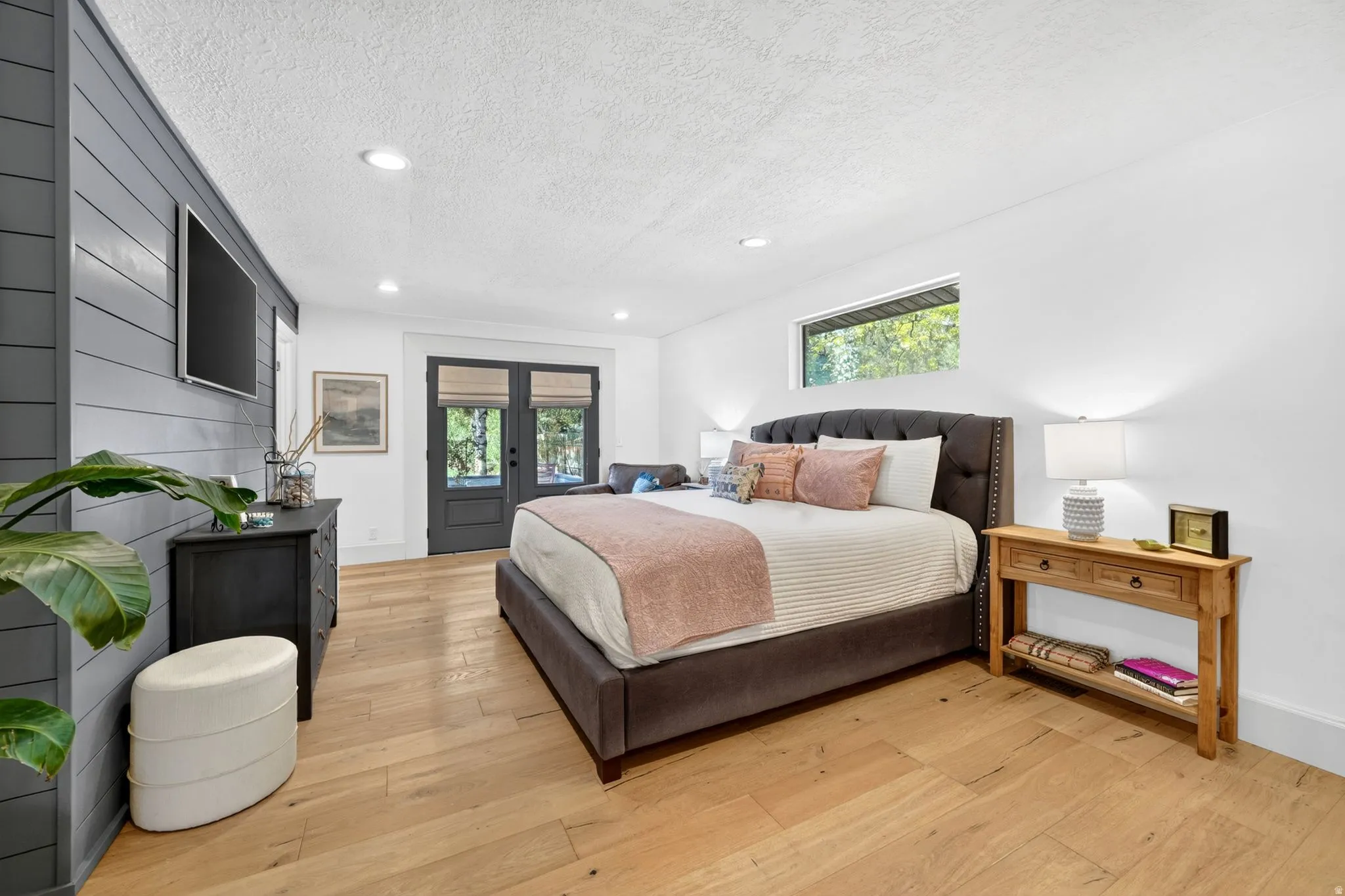 Spacious room featuring light wood-finish flooring and a shiplap accent wall