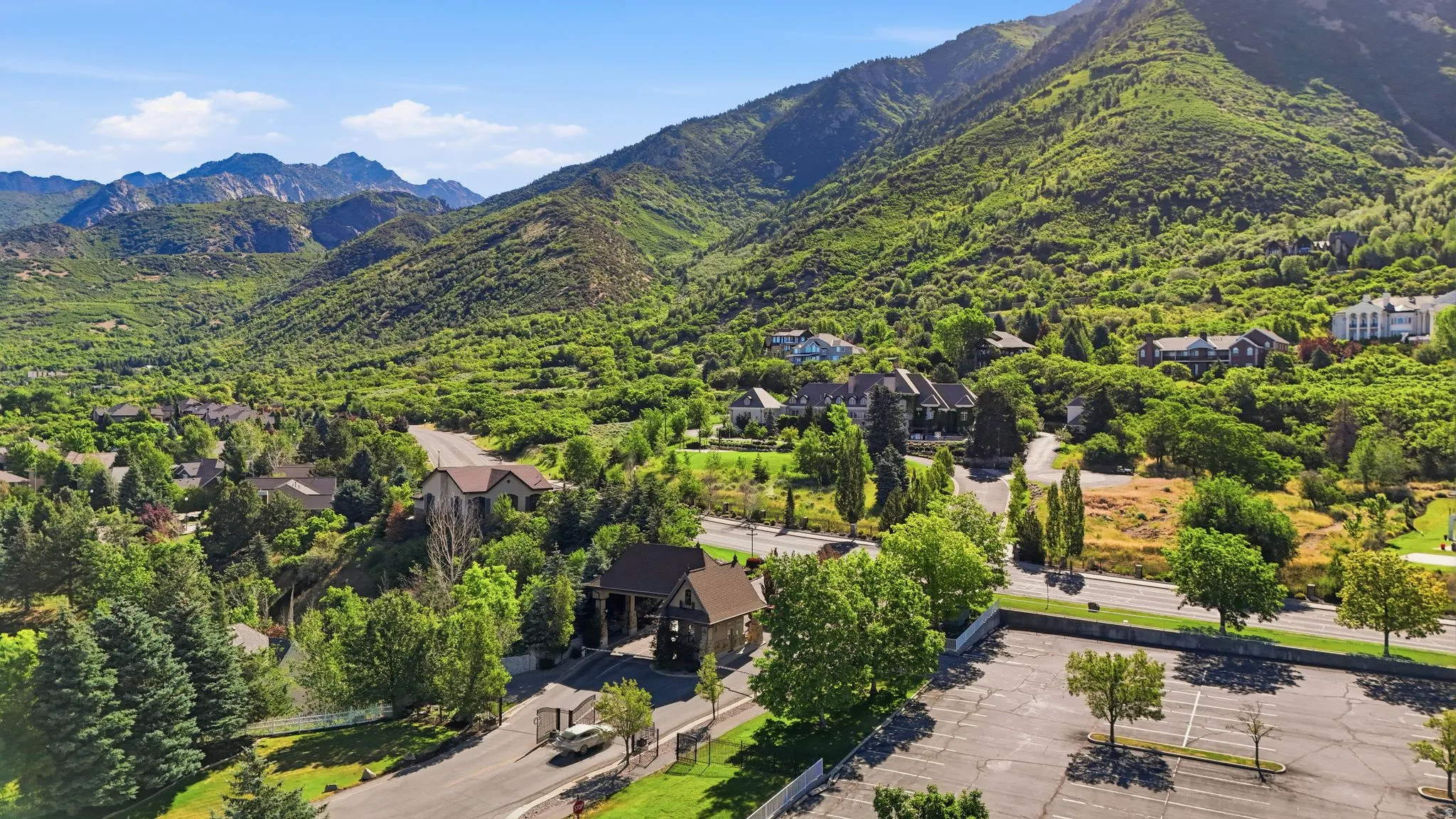 Mountain-backed community featuring mature trees, residential properties with varied architectural styles, and paved roads