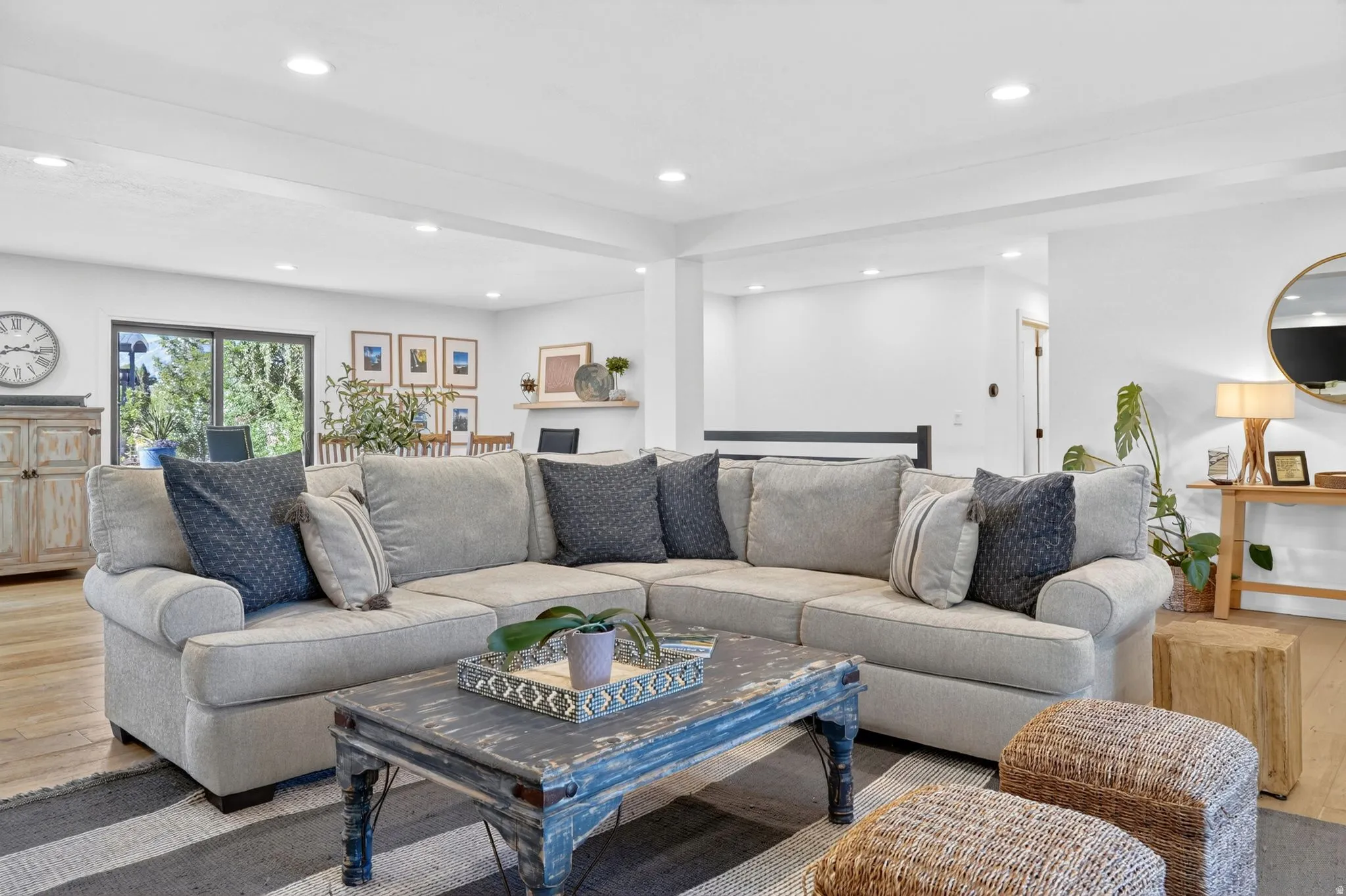 Spacious living area featuring light wood-finish flooring, recessed lighting, and white painted walls