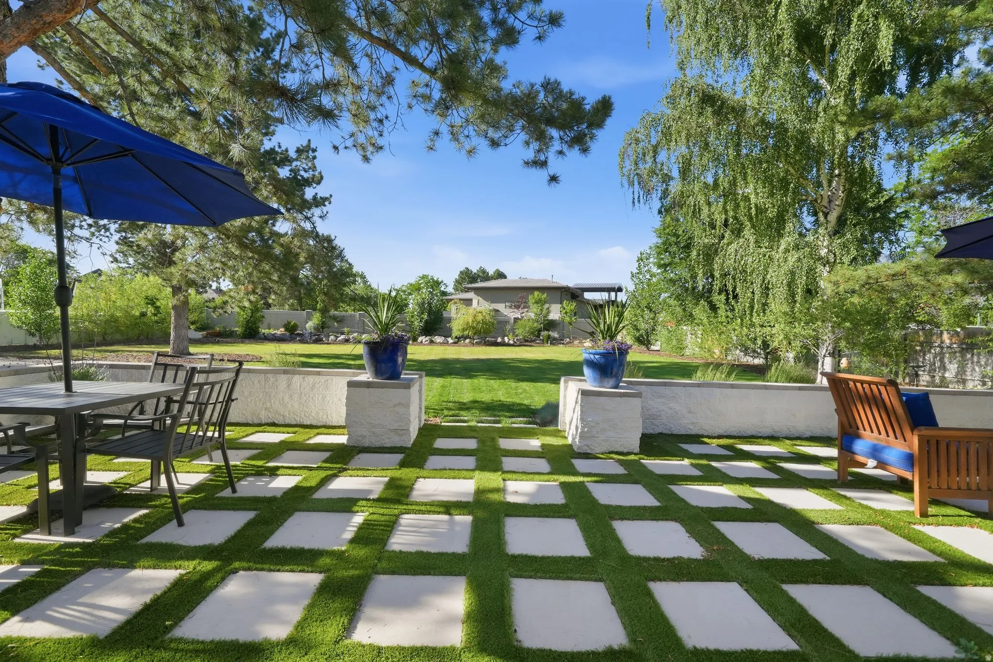 Expansive outdoor patio featuring paver-style stepping stones set in artificial turf