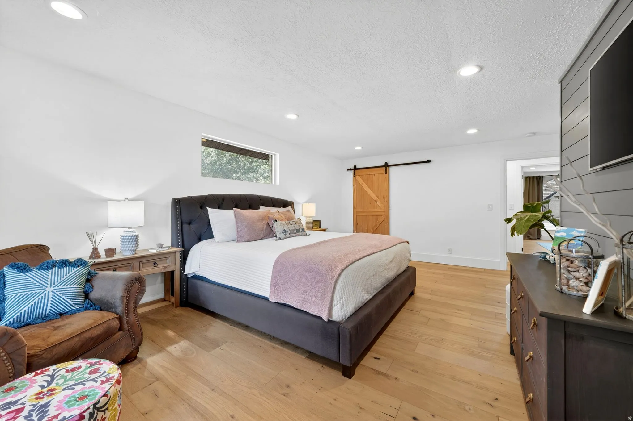Bright room featuring light wood-finish flooring, recessed lighting, and a horizontal window