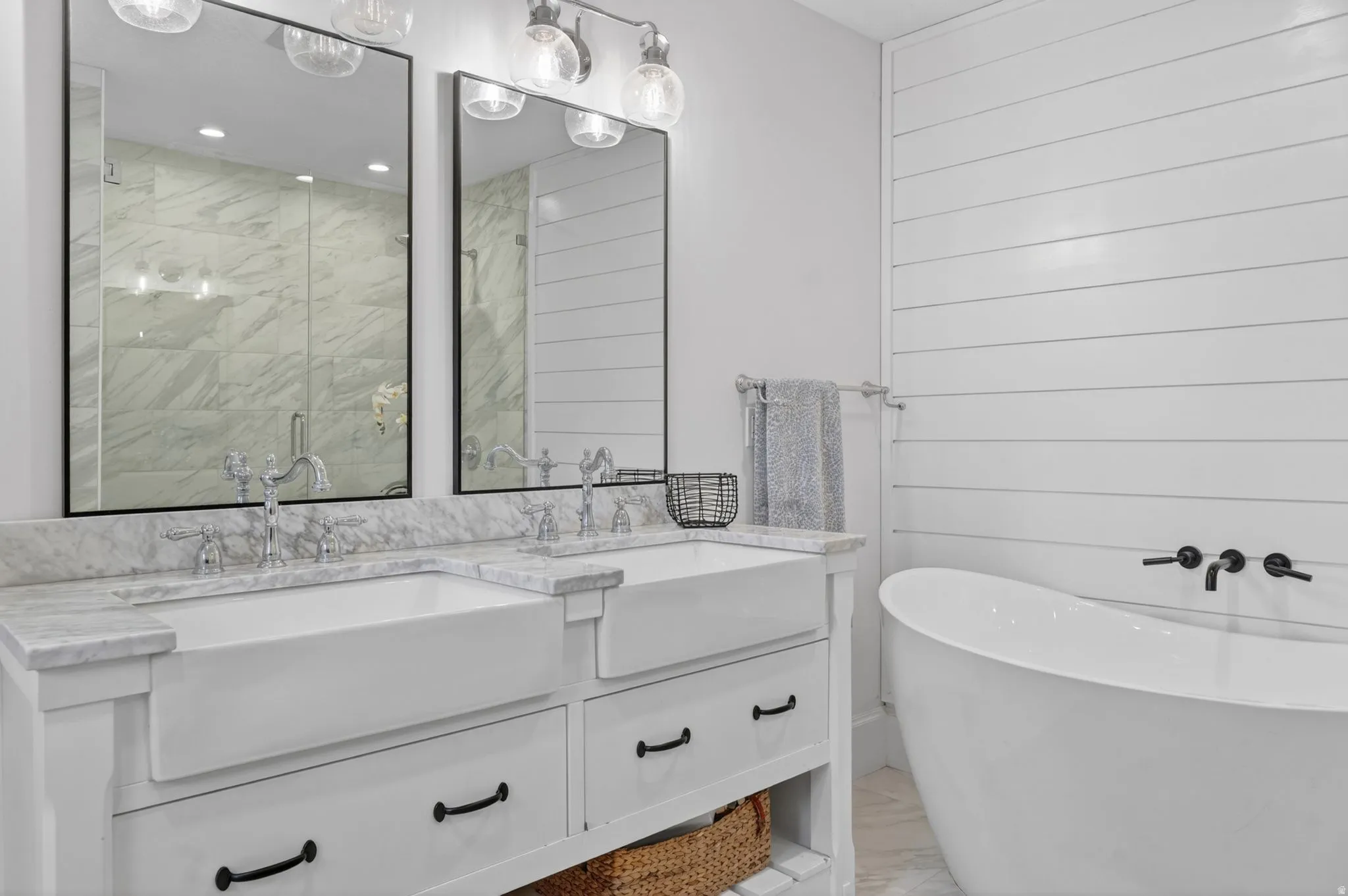 Dual vanity with farmhouse sinks, marble-finish countertop, and chrome fixtures