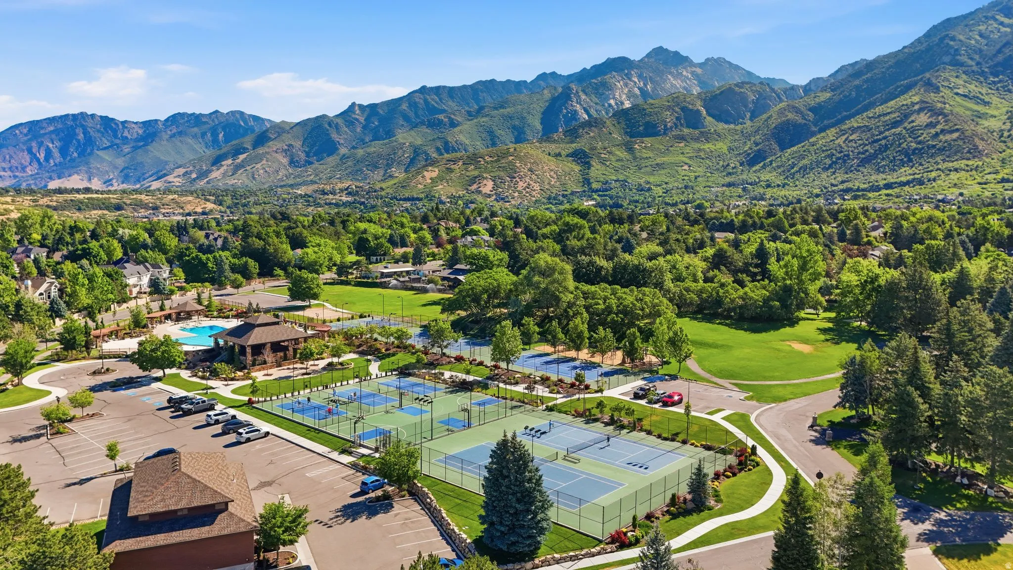 Expansive community grounds featuring multiple tennis courts, pickleball courts, a large swimming pool, and a clubhouse