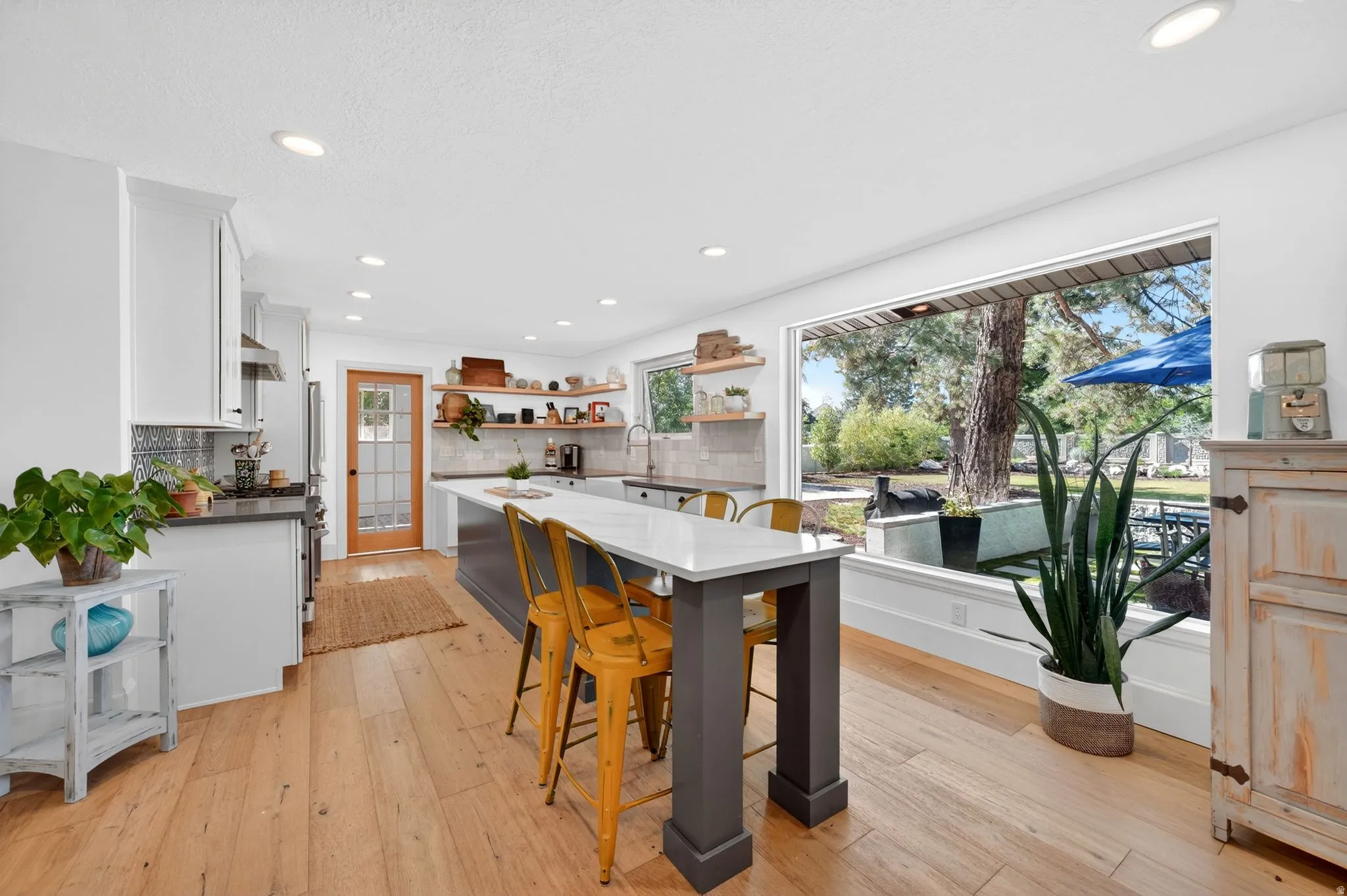 Spacious kitchen featuring light wood-finish flooring, recessed lighting, and a large picture window