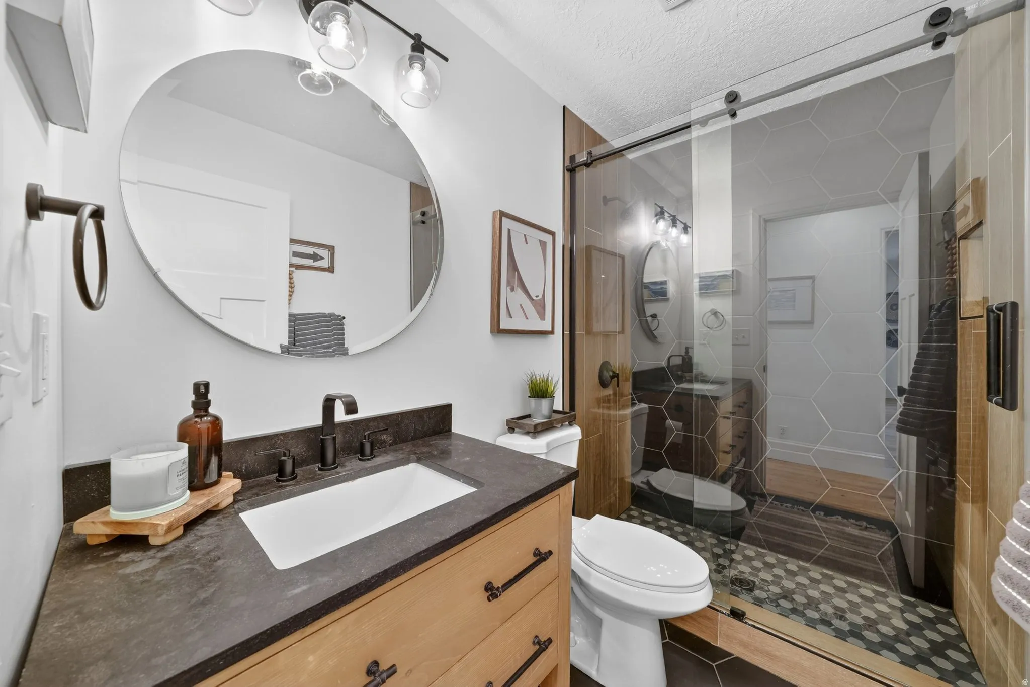 Bathroom featuring a light wood-finish vanity with a dark countertop and integrated sink