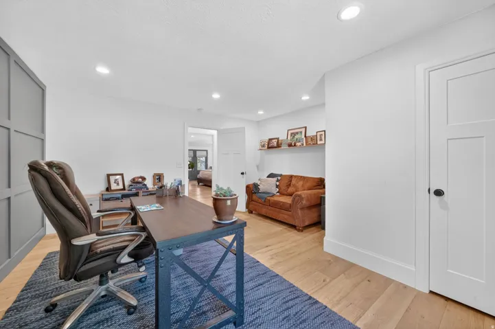 Dedicated office space featuring wood-finish flooring and recessed lighting
