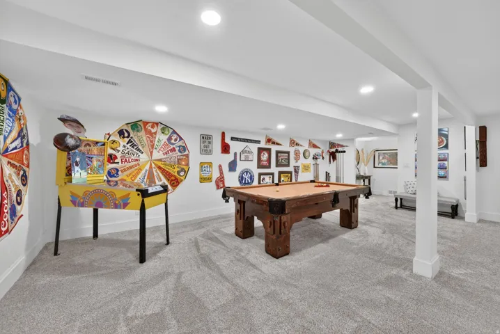 Spacious recreation area featuring a built-in pillar, recessed lighting, light gray carpeting, and white baseboards