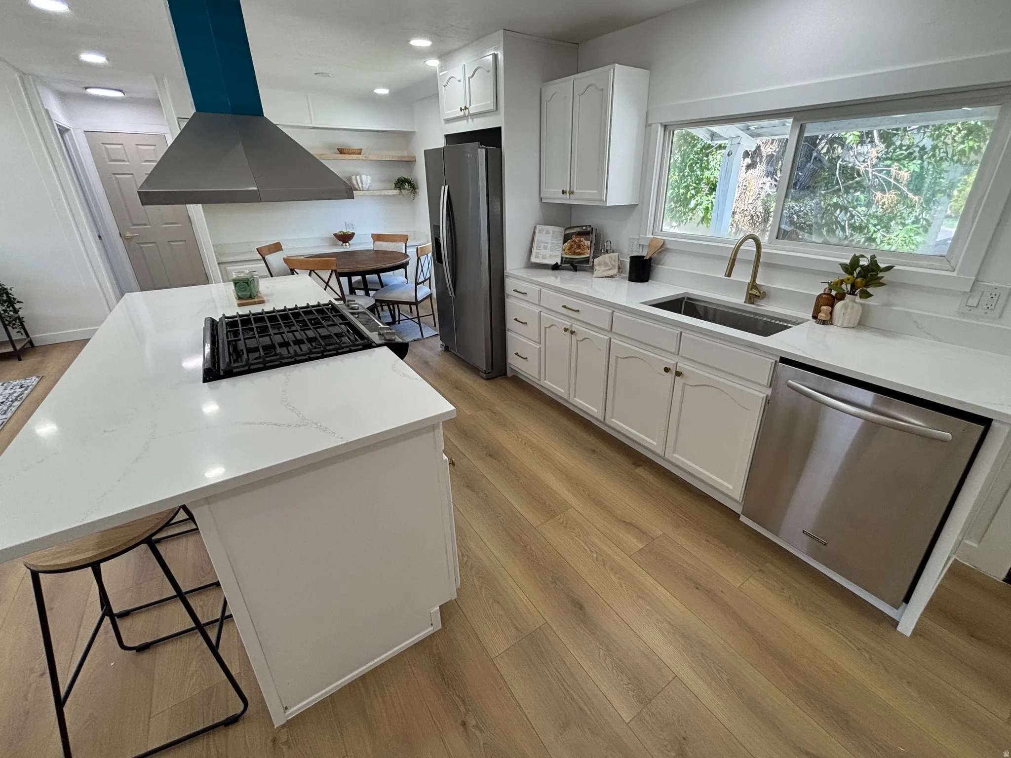 Kitchen featuring white cabinetry, light wood-finish flooring, and white countertops