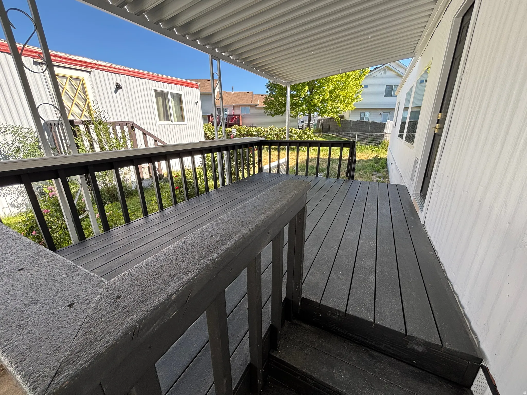 Expansive outdoor deck with composite decking and railing, featuring a covered patio area and exterior siding