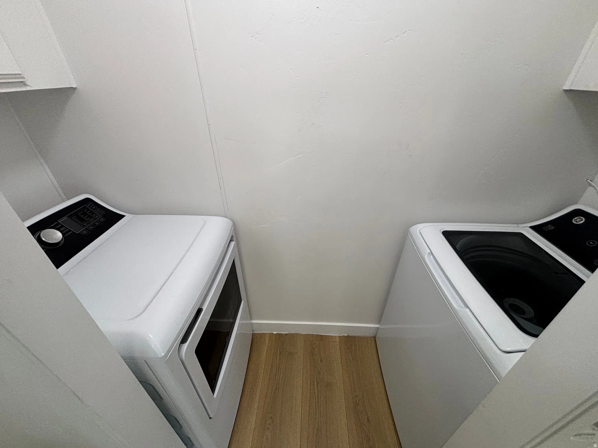 Dedicated laundry area featuring wood-finish flooring