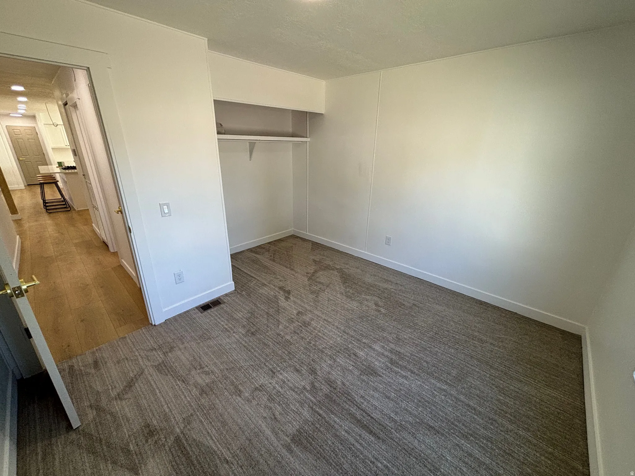Room featuring light-colored walls and grey patterned carpet