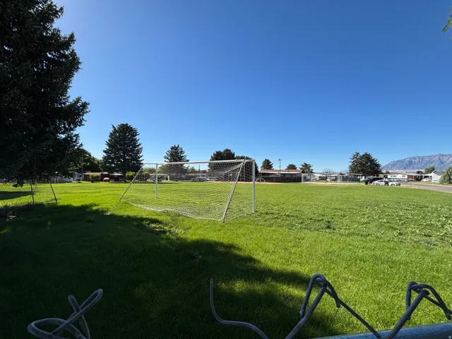 Expansive green field featuring a prominent soccer goal