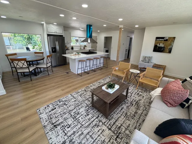 Open-concept living space featuring wood-finish flooring, recessed lighting, and white walls