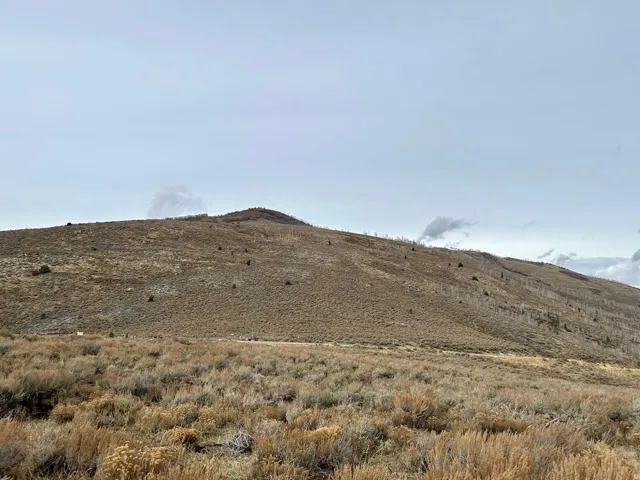 Expansive land parcel featuring natural topography, sparse vegetation, and distant mountain ranges