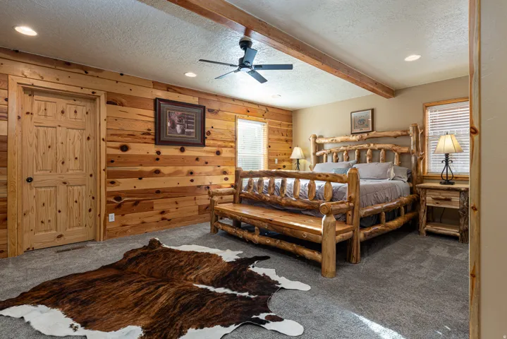 Interior room featuring knotty pine paneling, wood-finish door, textured ceiling, recessed lighting, and a ceiling fan
