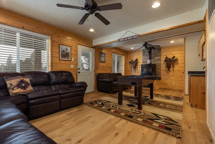Spacious interior featuring wood-finish flooring, paneled walls, and a stone-accented wood stove