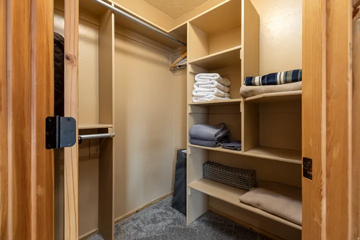 Custom closet system featuring built-in shelving, hanging rods, and wood-finish doors