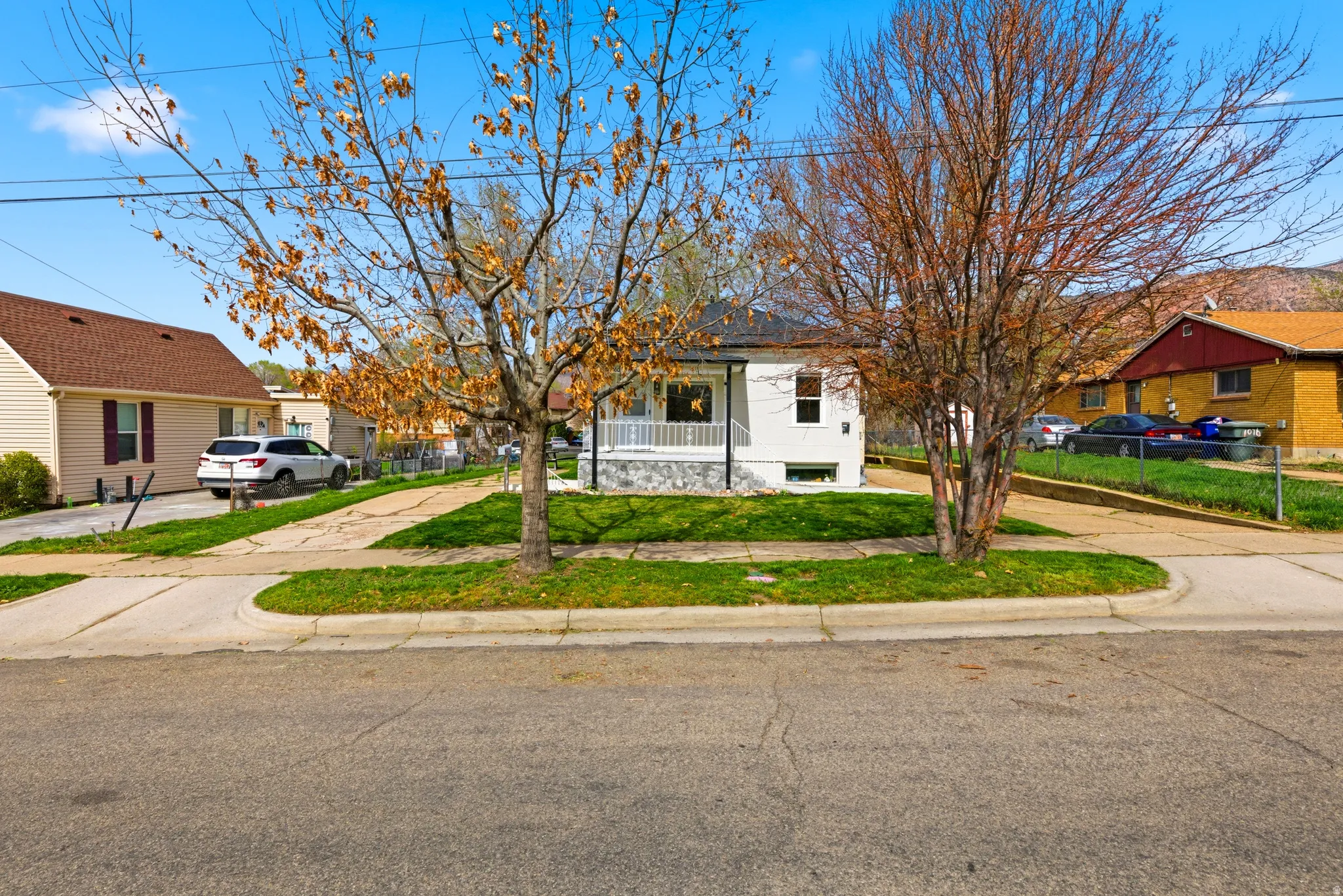 Bungalow with a residential view, a porch, a front lawn, and concrete driveway
