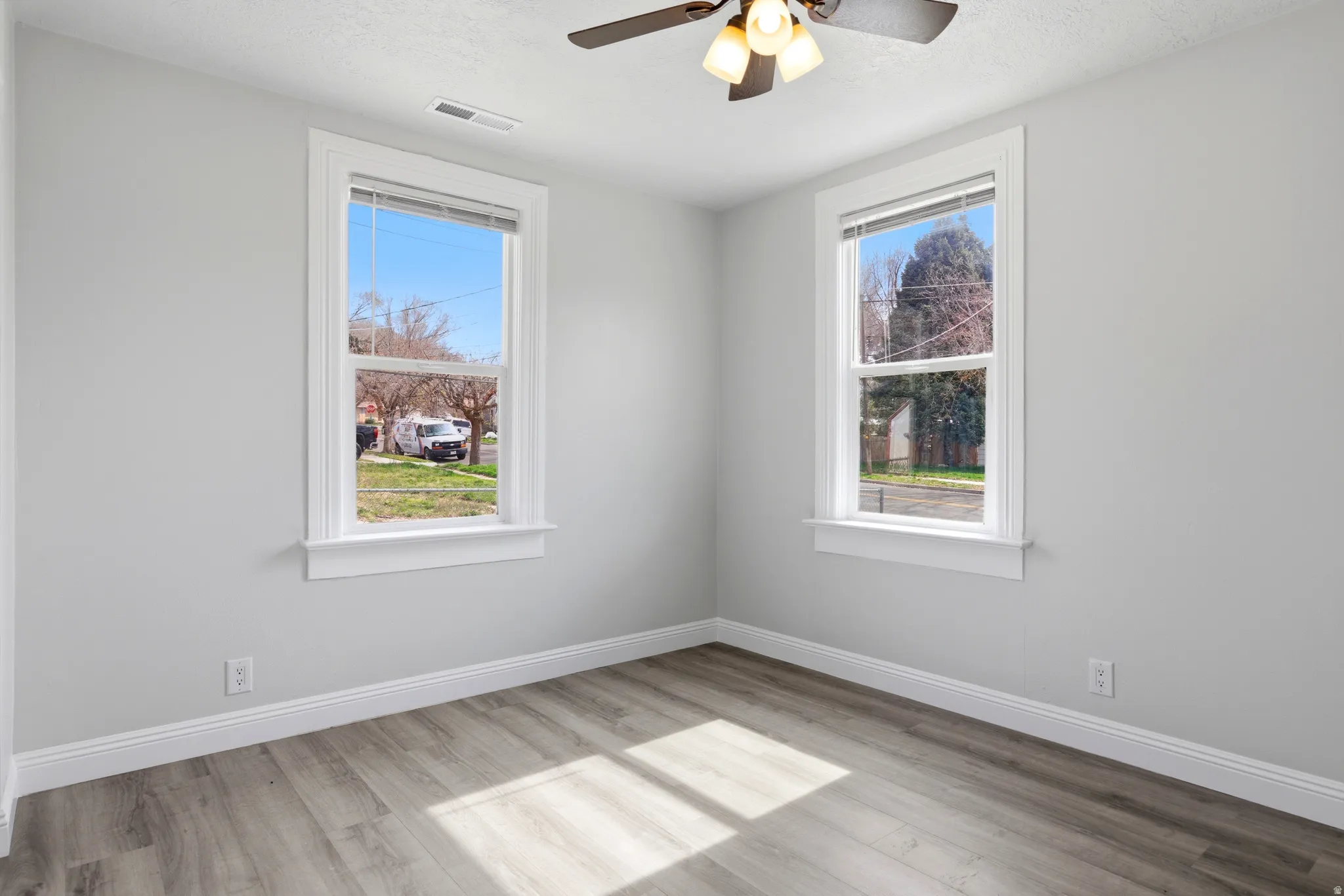 Unfurnished room with light wood finished floors and a ceiling fan