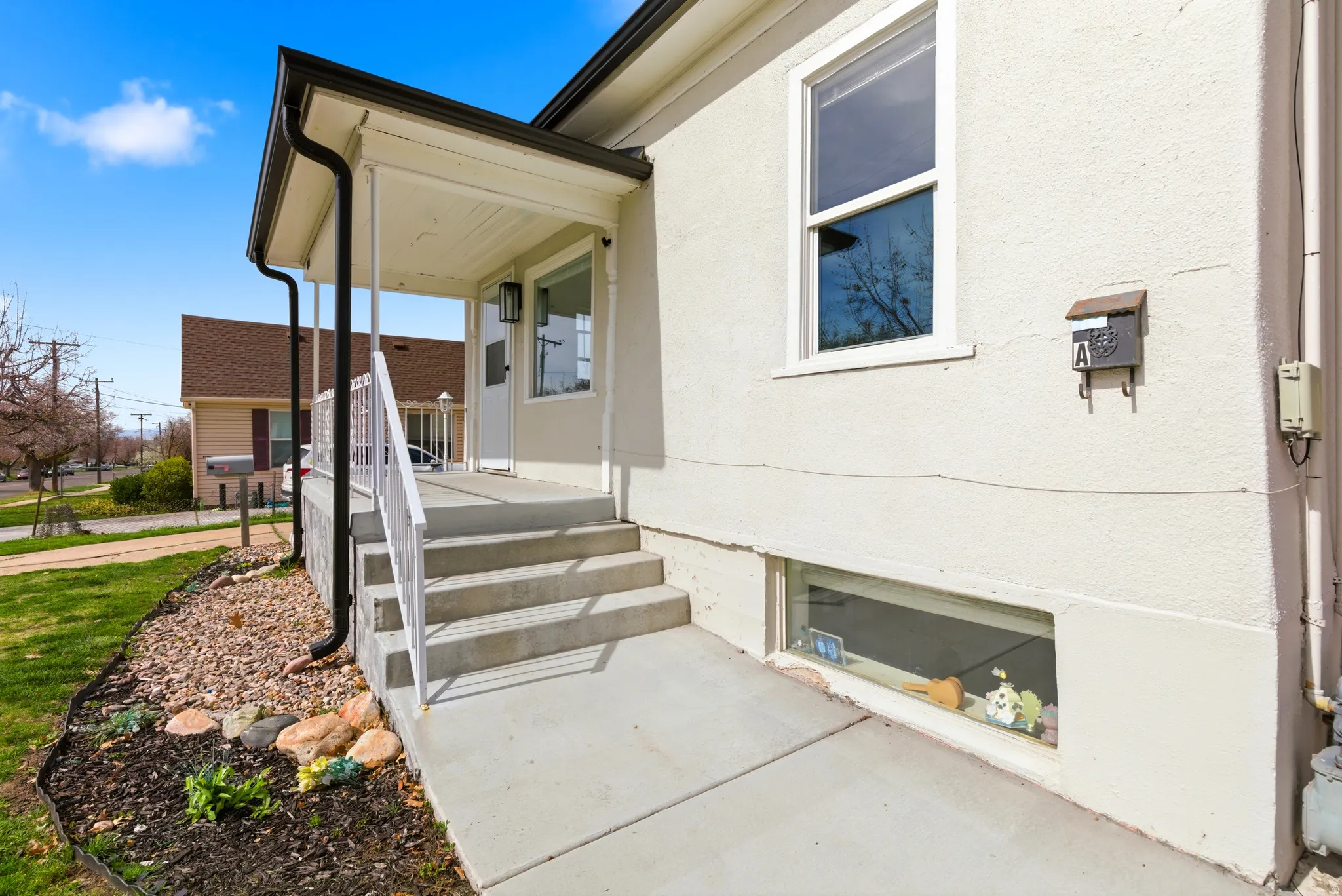 View of exterior entry with a porch and stucco siding