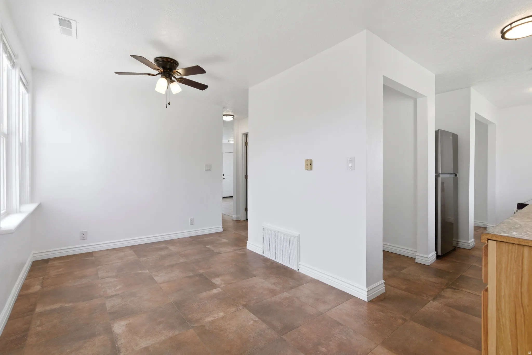 Spare room with ceiling fan and baseboards
