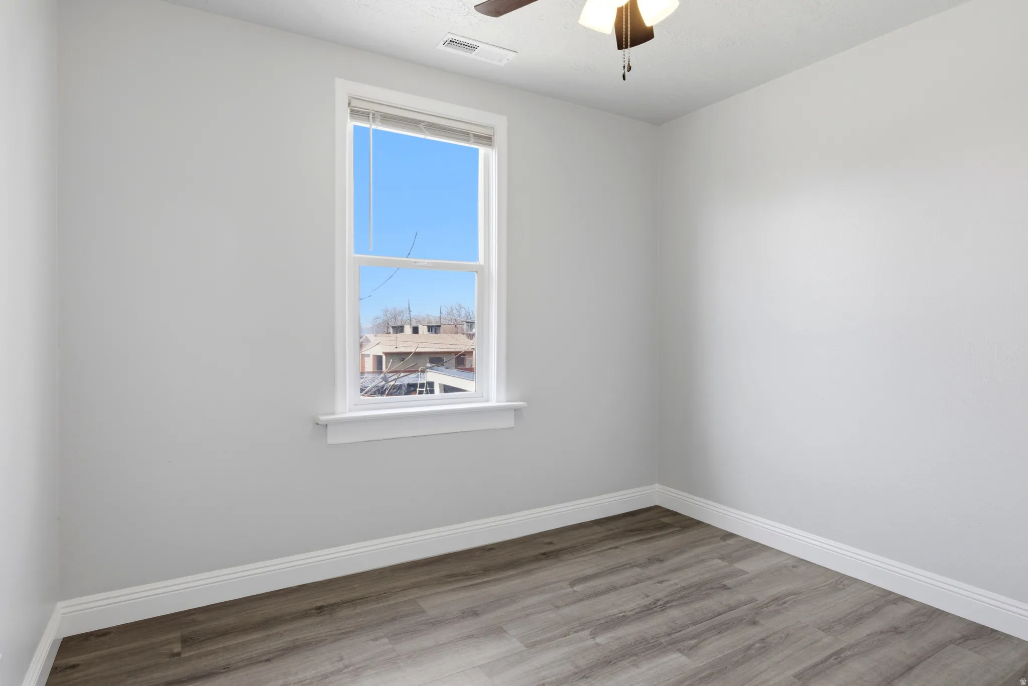 Empty room with light wood-type flooring and a ceiling fan