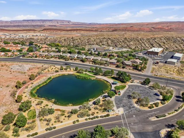 Aerial landscape showcasing a community pond surrounded by paved pathways and desert landscaping