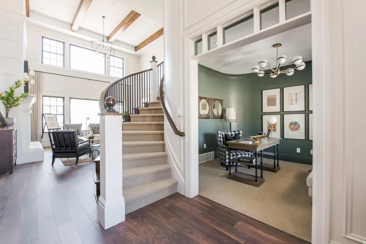 Two-story foyer with a curved staircase featuring dark wood-finish flooring