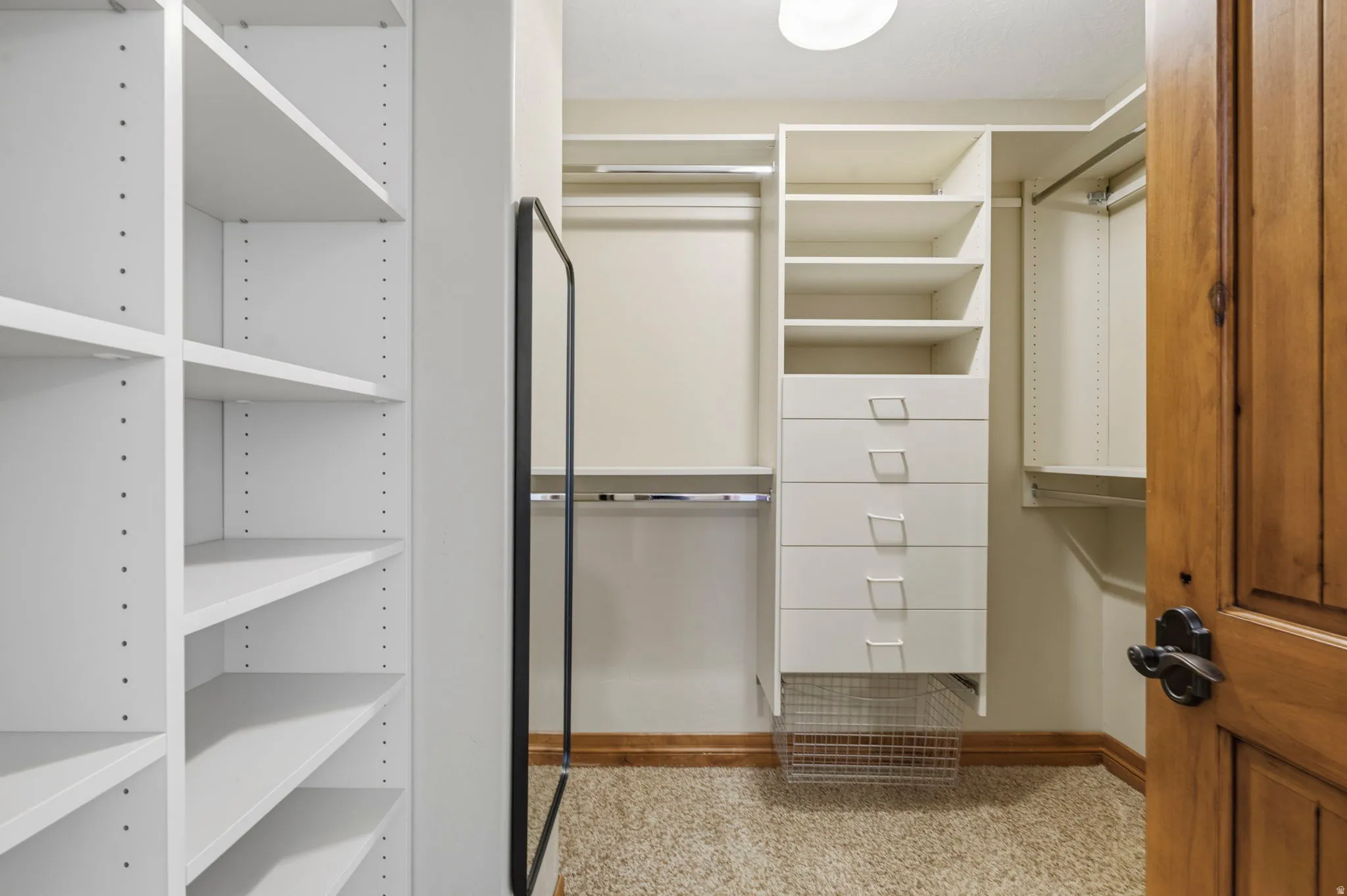 One of two Custom closet system featuring extensive shelving, built-in drawers, and multiple hanging rods