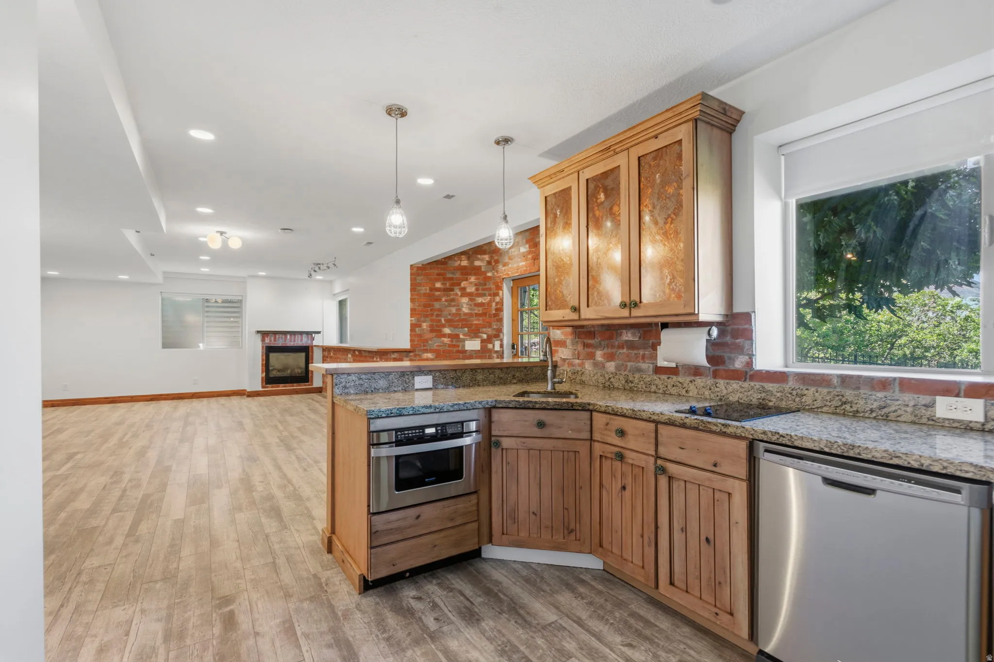 Basement open-concept kitchenette and living area featuring granite countertops.