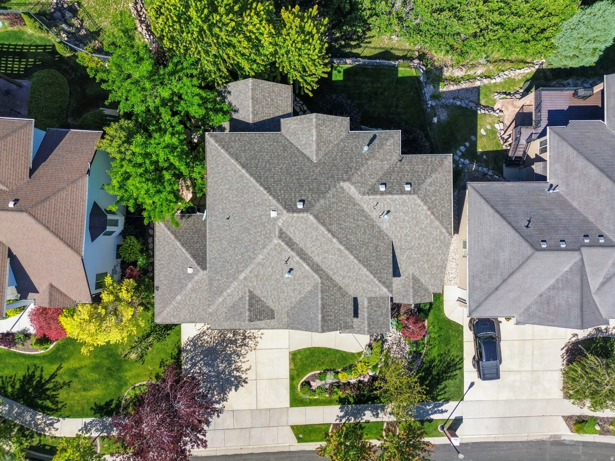 Expansive property featuring a multi-gabled roofline, mature landscaping, large trees.