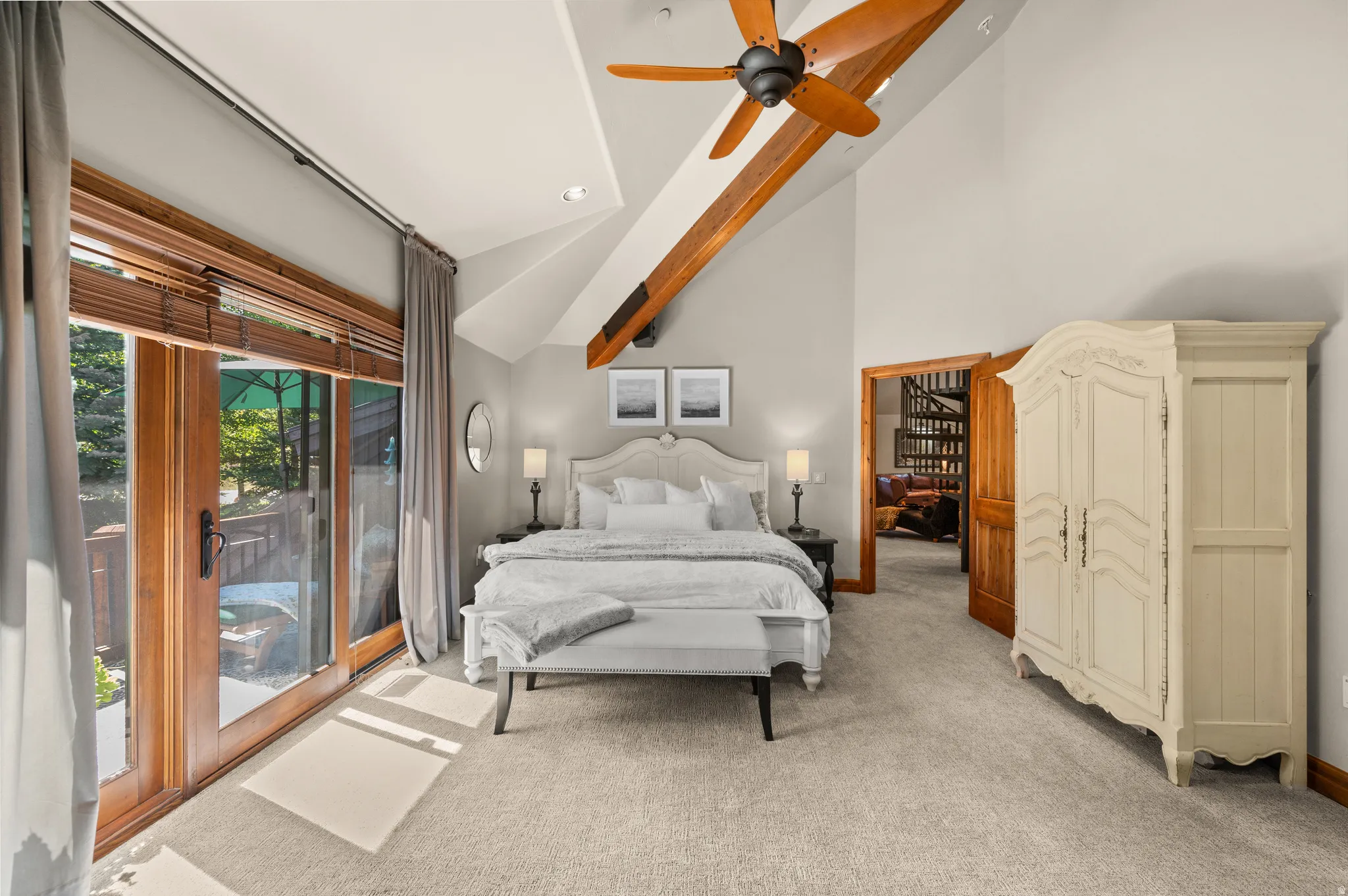 Bedroom with light colored carpet, a ceiling fan, and lofted ceiling