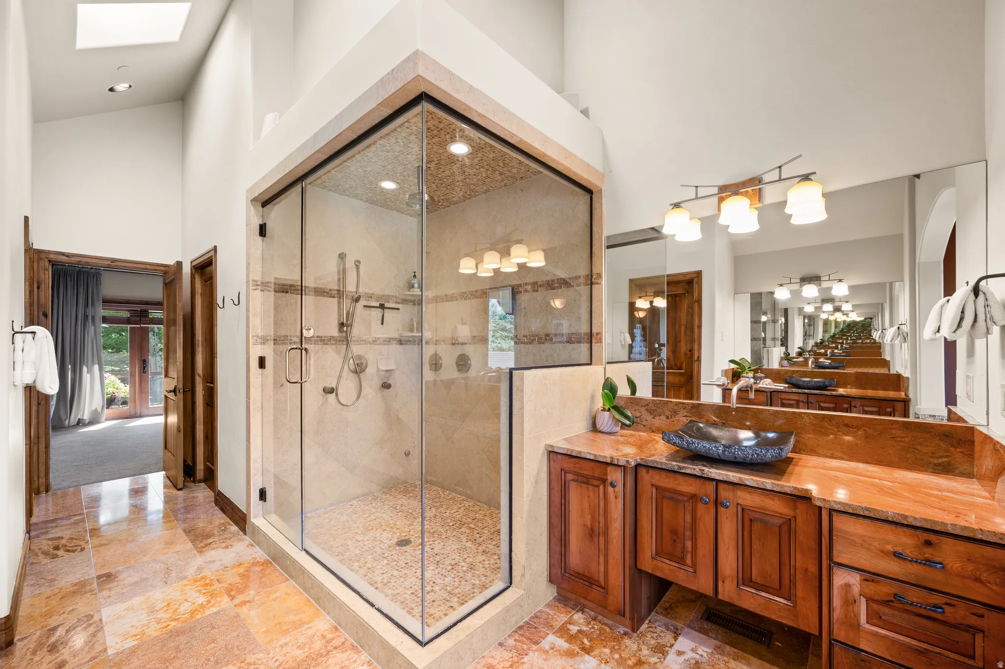 Bathroom featuring vanity, a high ceiling, a stall shower, and recessed lighting