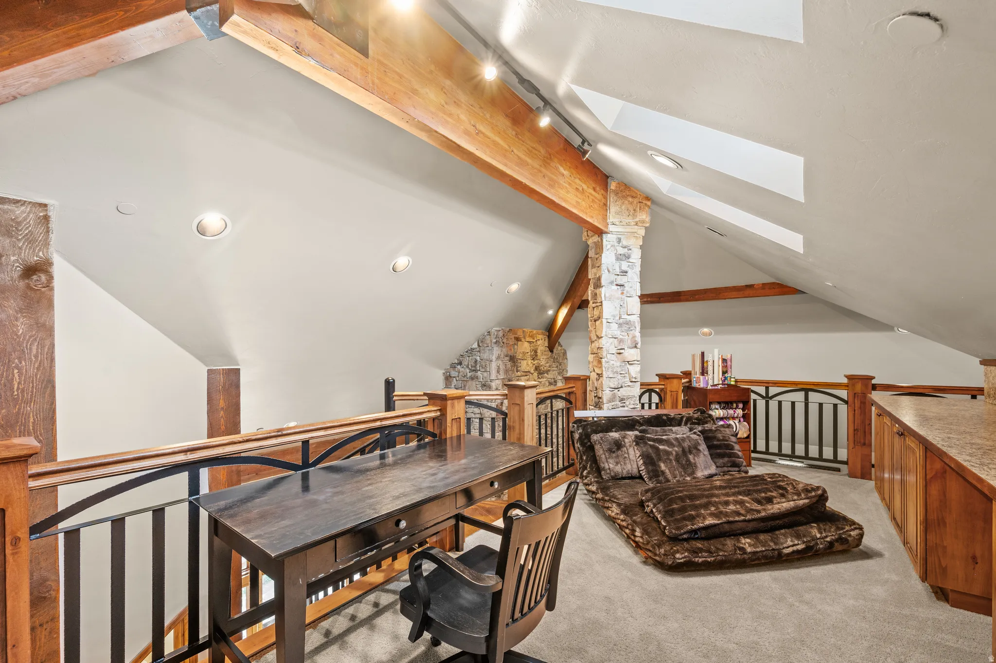 Office space with beam ceiling, light carpet, ornate columns, and a skylight