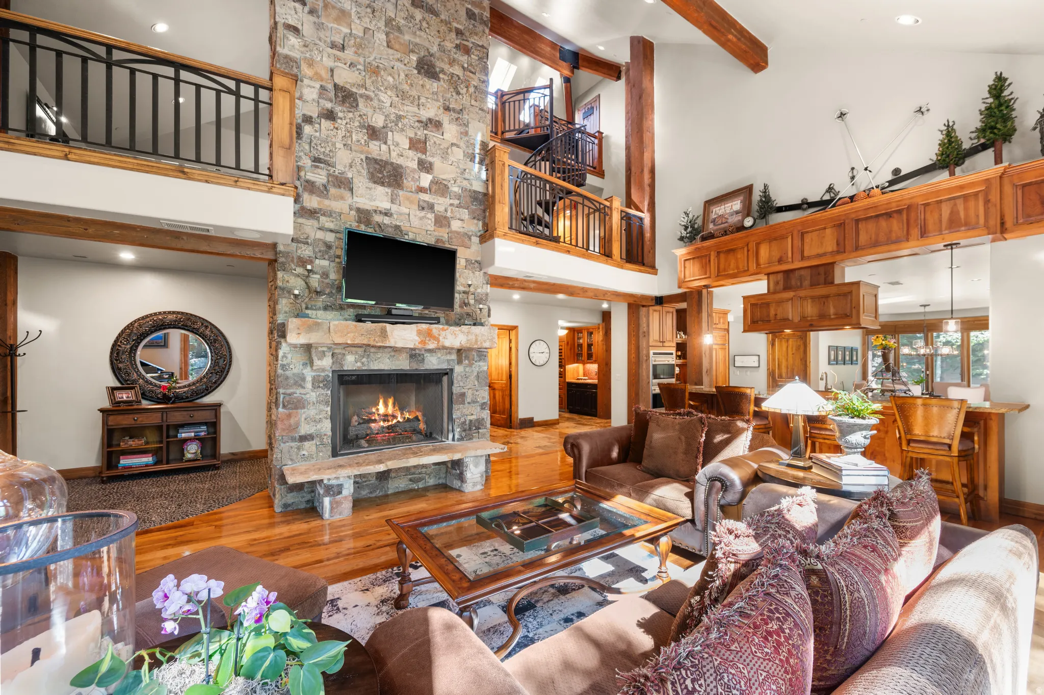 Living area with a stone fireplace, wood finished floors, recessed lighting, and lofted ceiling