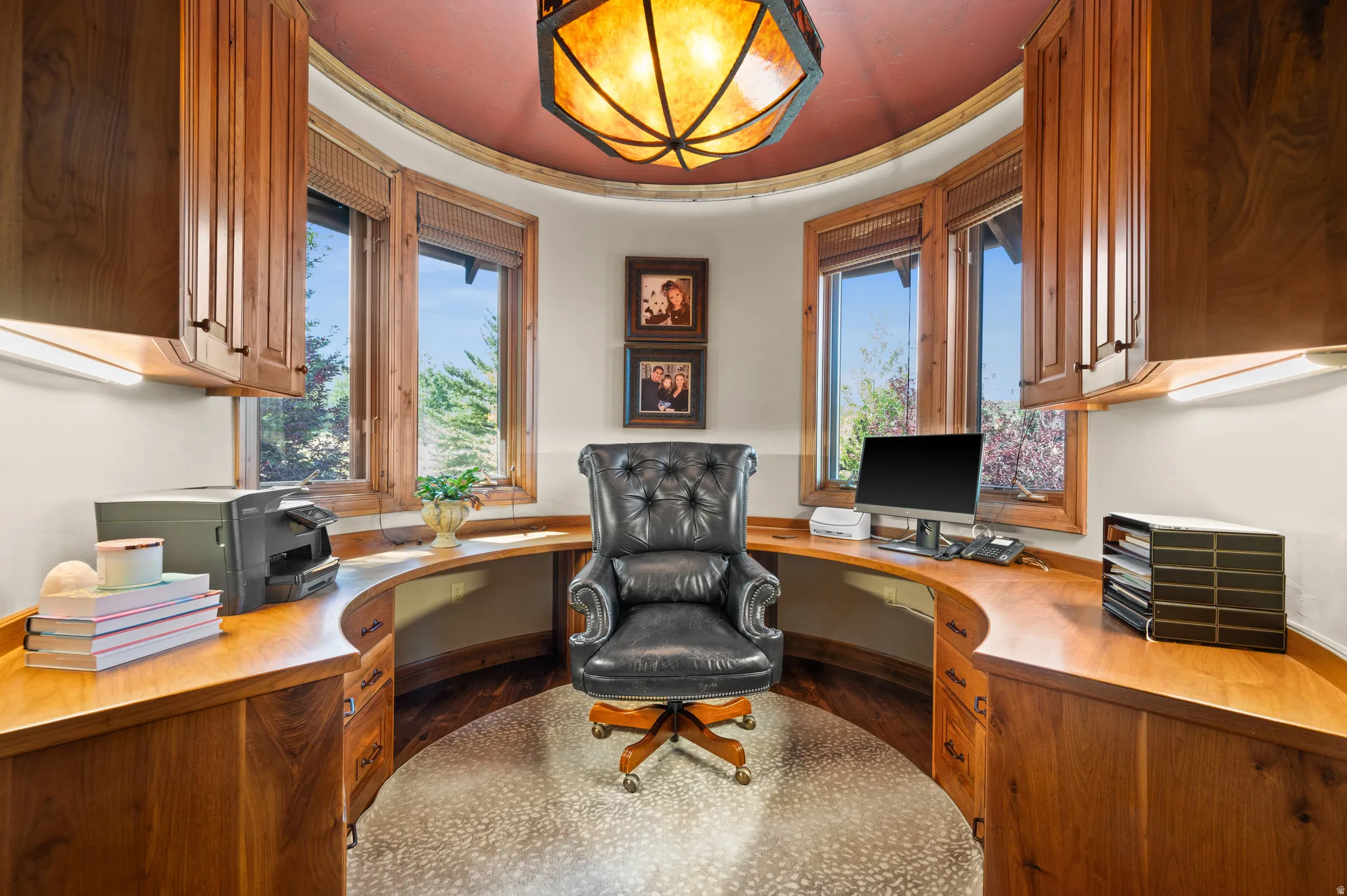 Office space with built in study area, dark wood finished floors, and healthy amount of natural light