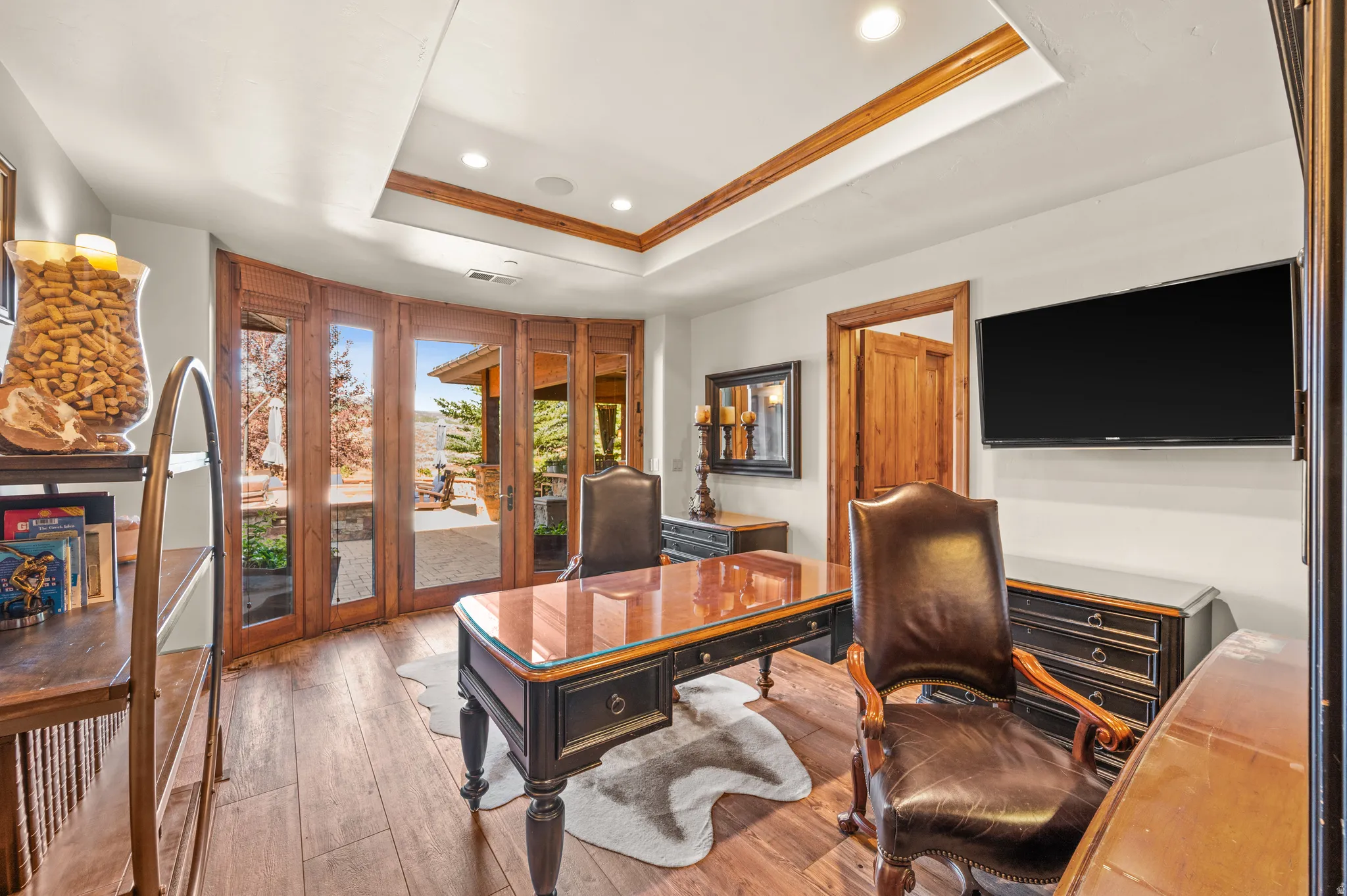 Office area with wood-type flooring, recessed lighting, a raised ceiling, and ornamental molding