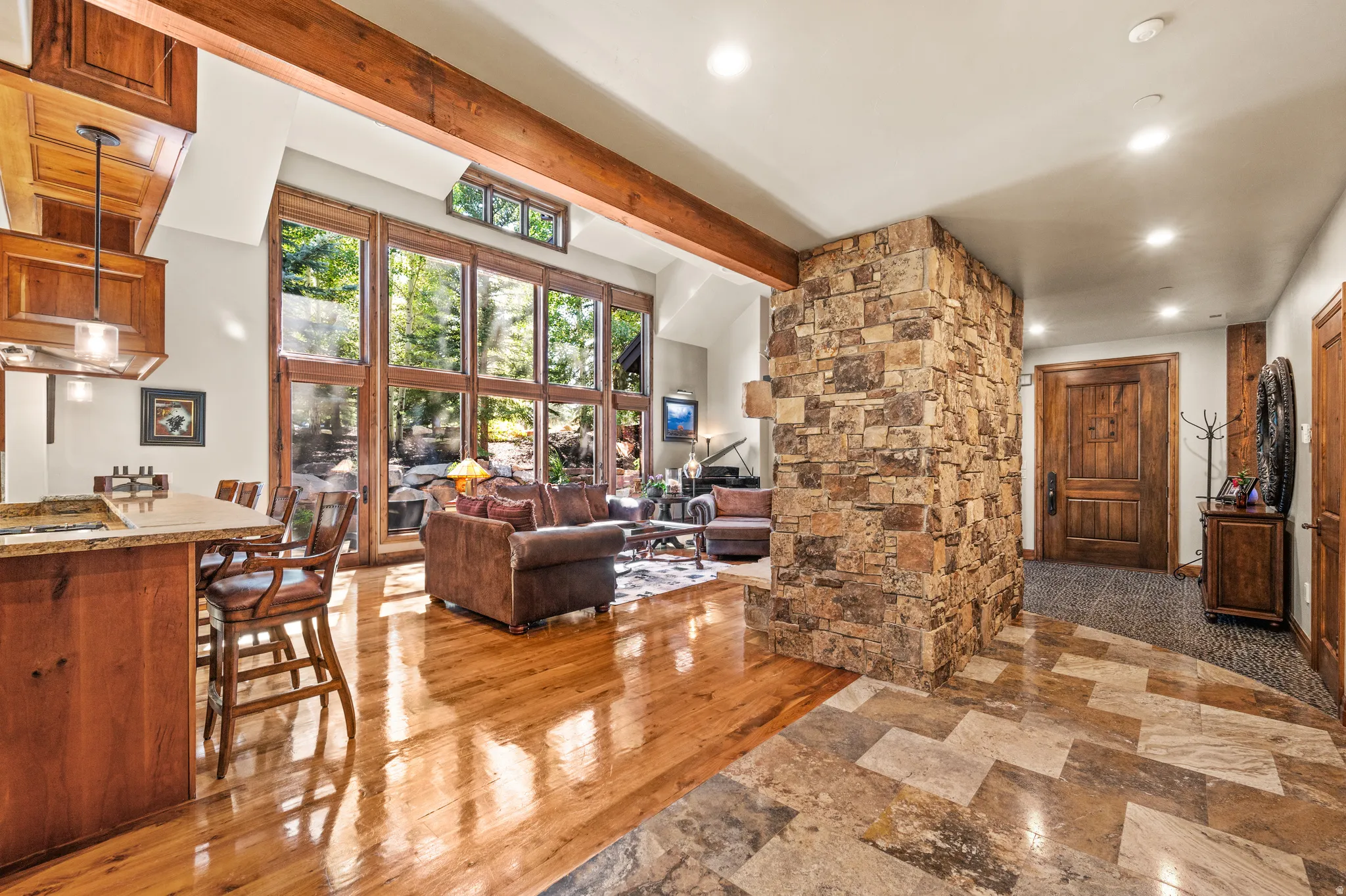 Living room featuring recessed lighting, vaulted ceiling with beams, and light stone finish floors
