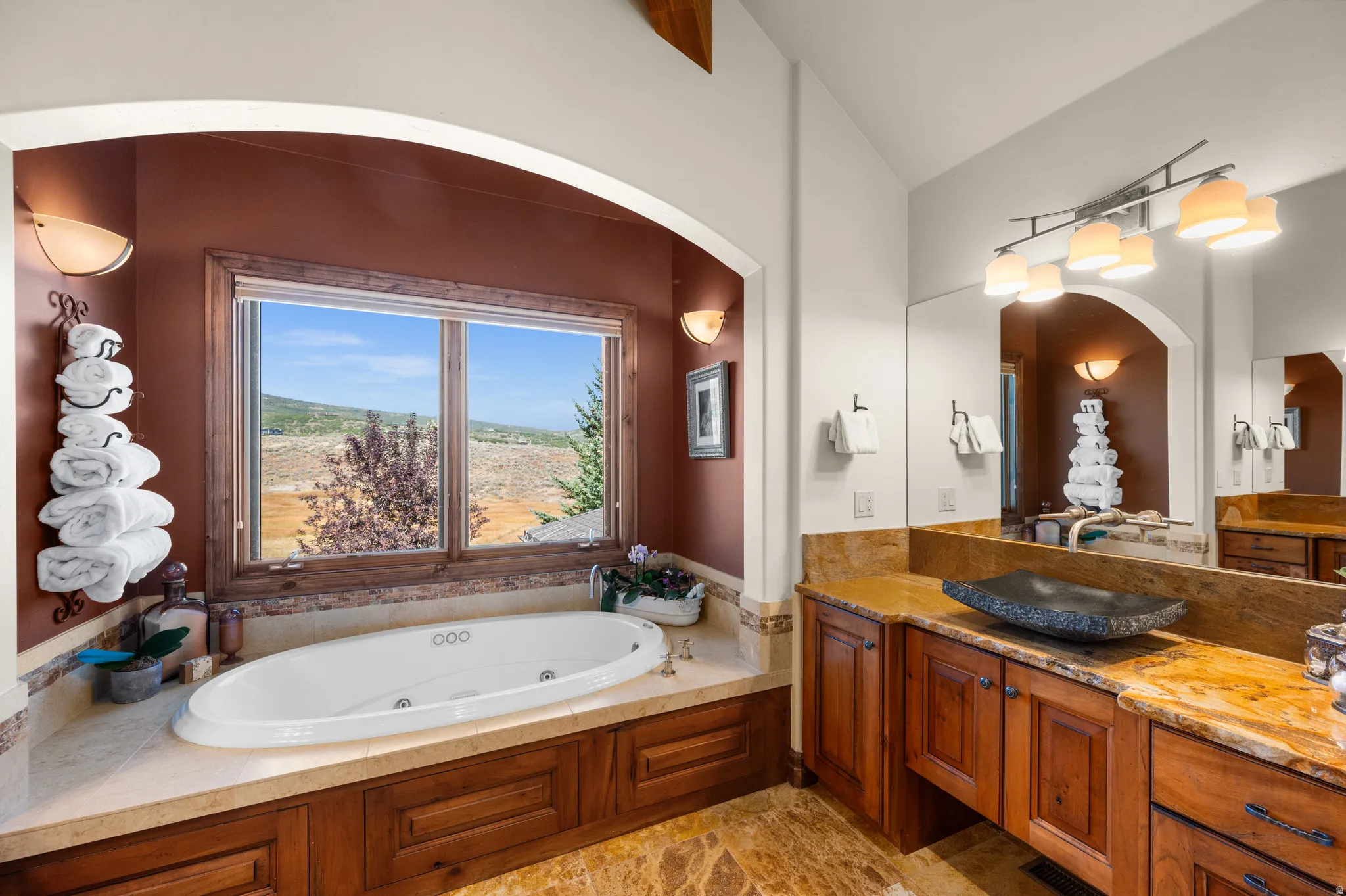 Full bathroom with vanity, vaulted ceiling, and a whirlpool tub