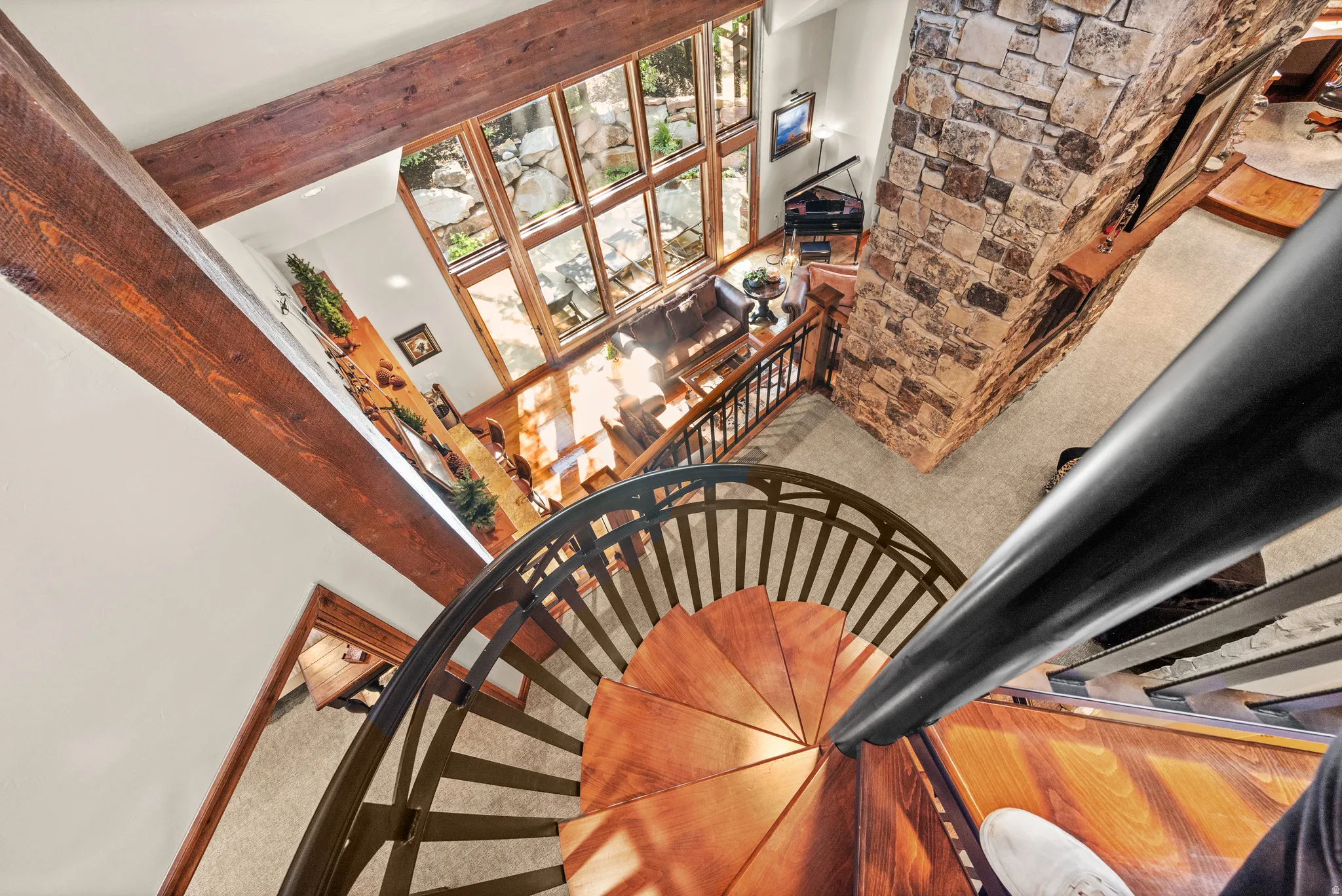 Staircase with carpet flooring, a high ceiling, and a stone fireplace